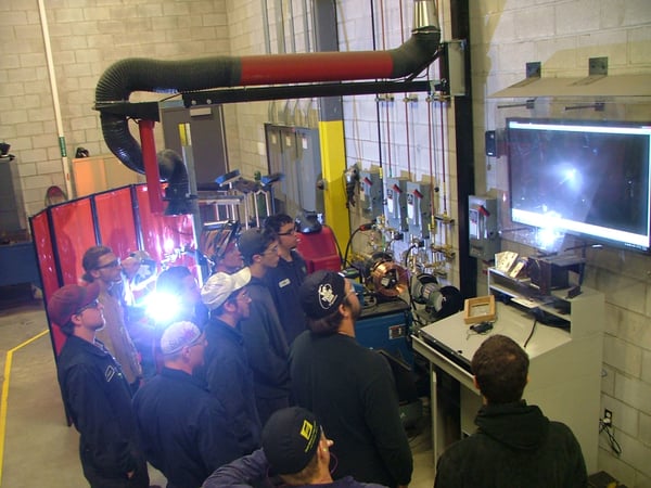 Students viewing a weld demo from a large screen