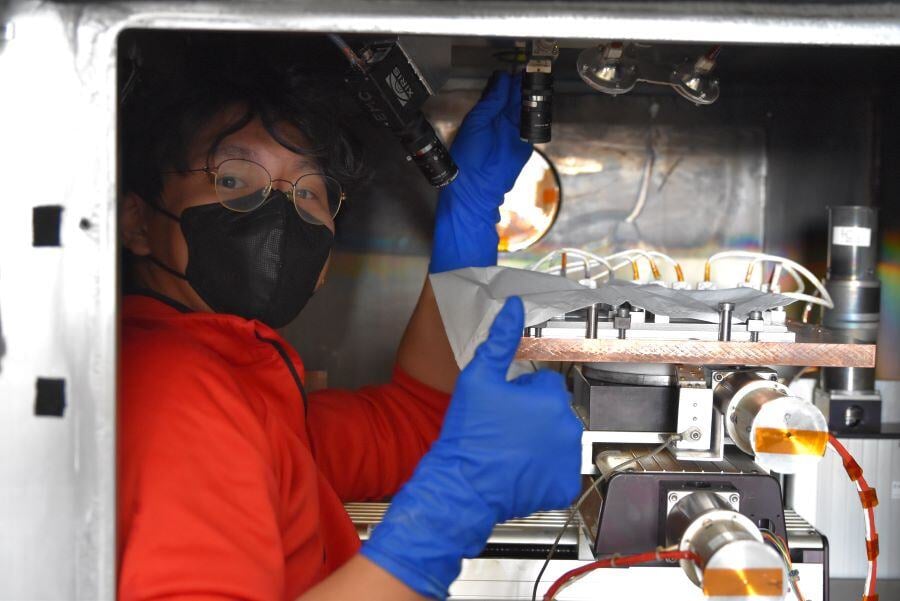 Ohio State University strudent Eugene Choi is adjusting the focus on Xiris Cameras in the vacume chamber